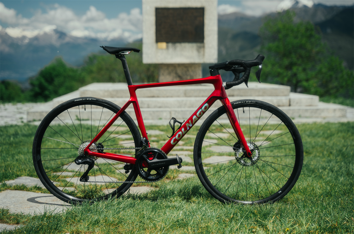 Rower szosowy Colnago stoi w górach na tle monumentu.